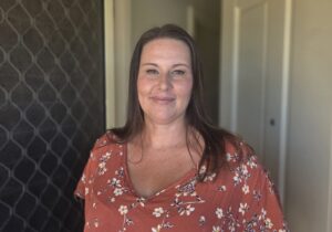 Woman in red top standing in front of door